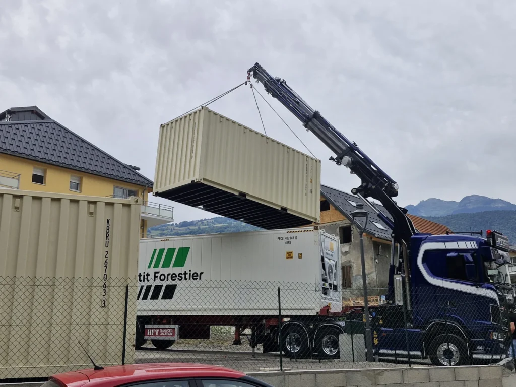 Levage d'un container maritime 20 pieds par grue auxiliaire en zone montagneuse