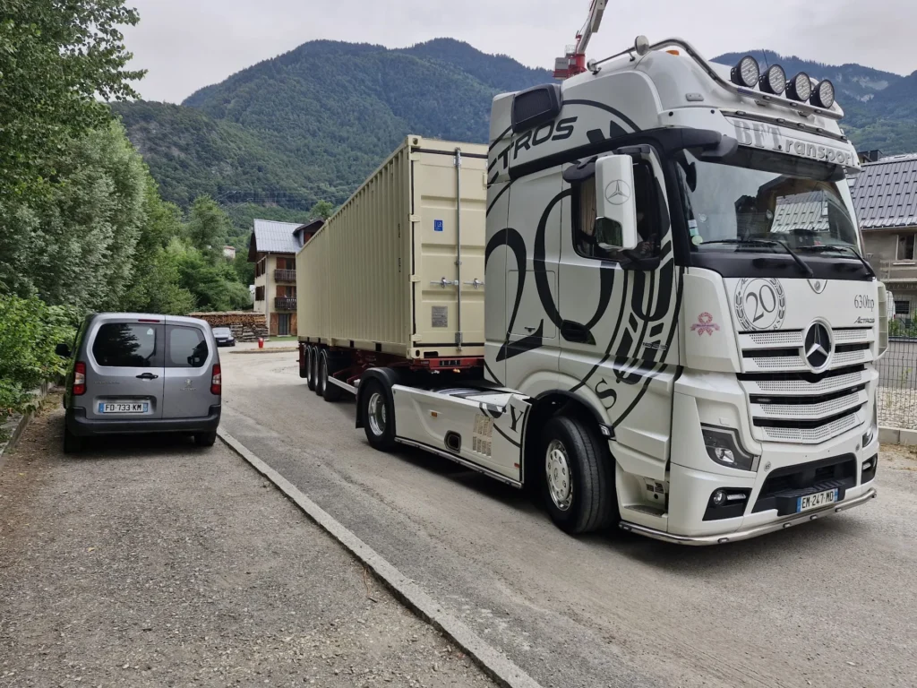 Semi-remorque BFT Transport livrant un container 20 pieds RAL 1015 en vallée de la Tarentaise