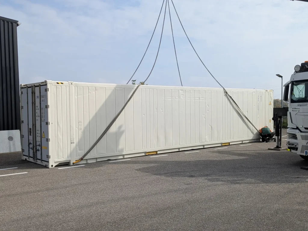 Levage d'un conteneur isotherme 45 pieds au camion-grue lors de la livraison à Erstein